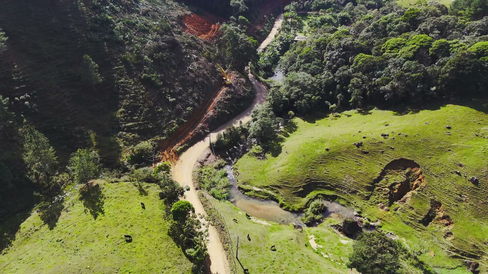 Vista aérea da área em supressão, com a faixa aberta na encosta, o acesso definido e a máquina posicionada